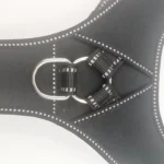 close-up of a black Y-shaped tactical dog harness with reflective stitching, strap adjustment, and metal hardware.